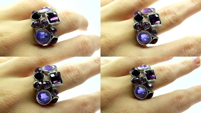 手指上镶有紫色水晶的珠宝戒指
