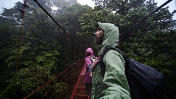 丛林中的年轻夫妇潮湿的树林驴友户外探险