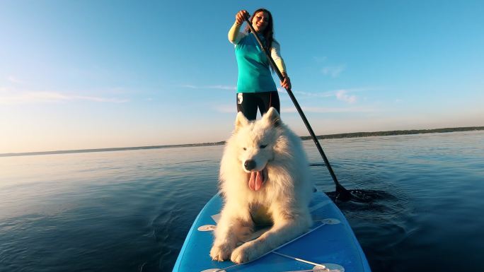 女孩和白狗萨摩耶犬橡皮筏极限运动