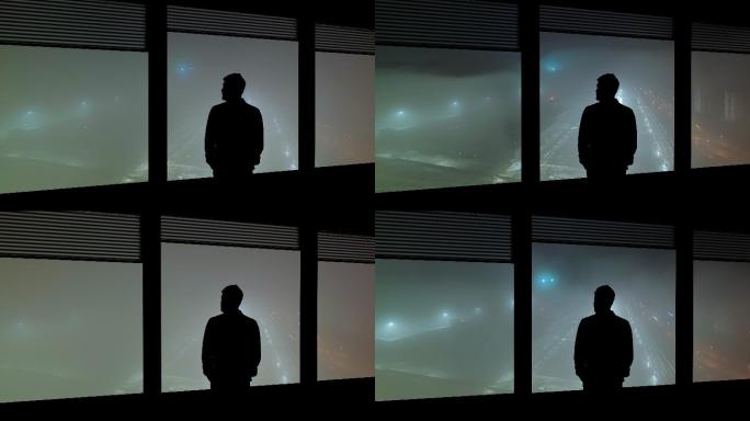 这个男人站在窗户附近眺望雨中城市