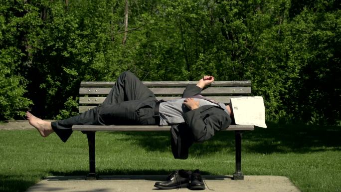 商人睡在公园的长椅上