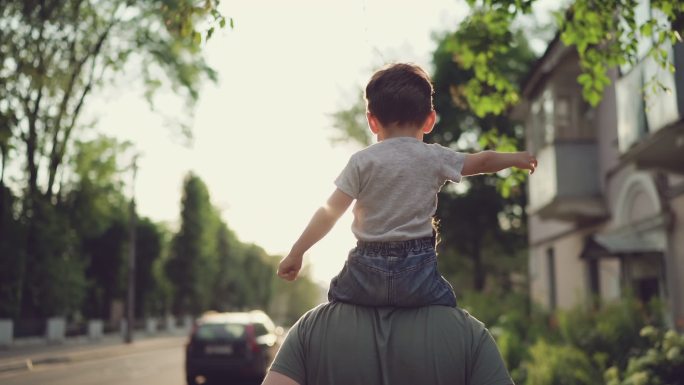 孩子在父亲肩膀上父子亲子时光逆光背影