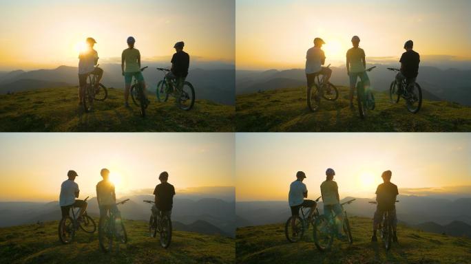 三个骑山地车的朋友在山顶看风景