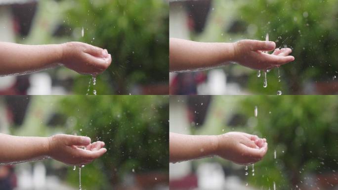 小孩子玩水的镜头雨滴掉落小孩玩水手接雨水