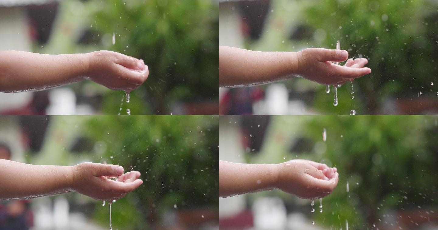 小孩子玩水的镜头雨滴掉落小孩玩水手接雨水