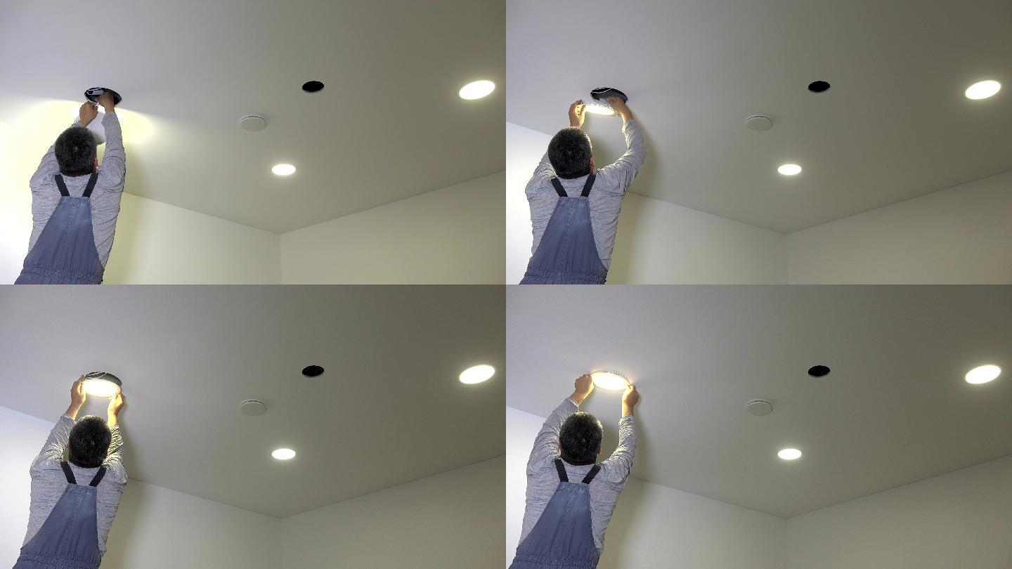 工匠将led灯面板连接并安装到天花板孔中