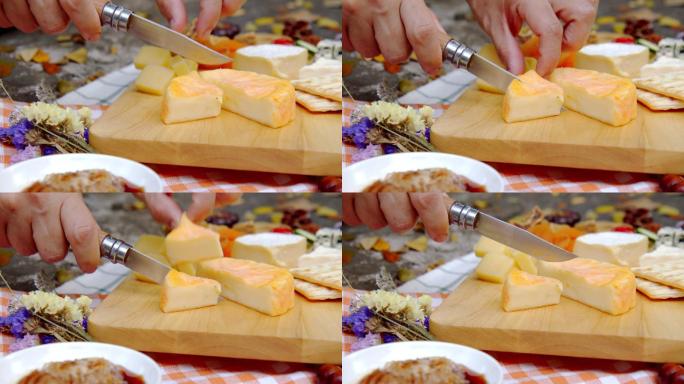 一个女人在一个奶酪盘子里切欧洲奶酪吃