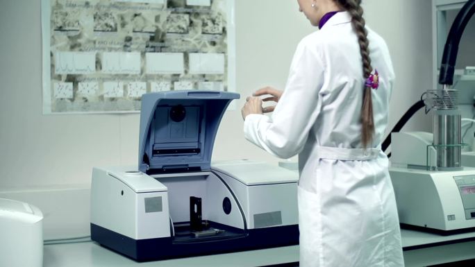 实验室助理用红外光谱仪检查科学实验结果