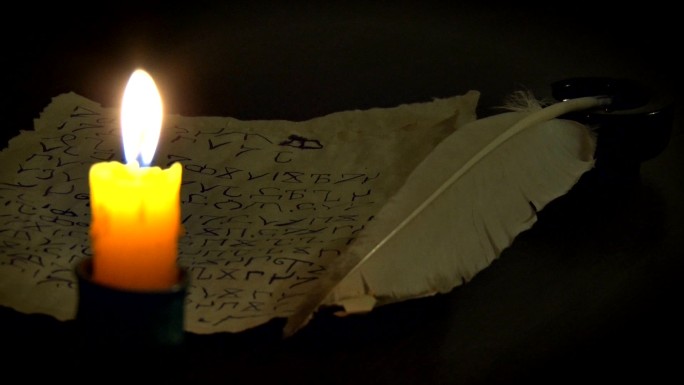 燃烧的蜡烛与古代手稿