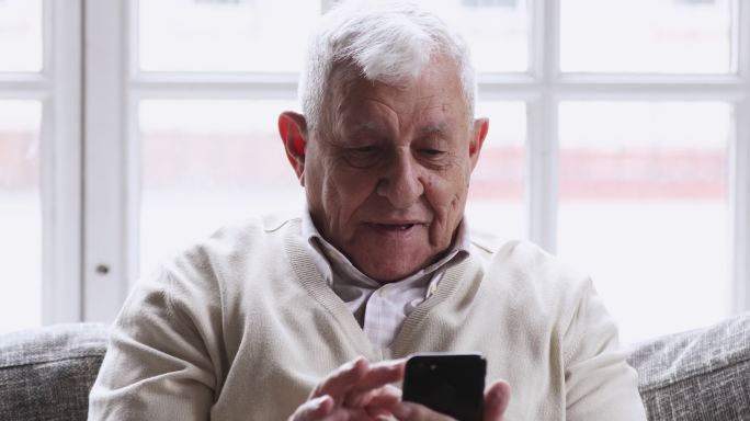 喜出望外的80多岁老人拿着手机