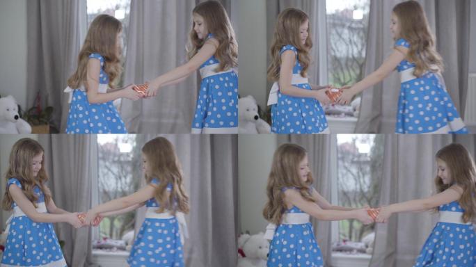 两个小女孩争夺礼物的侧视图。
