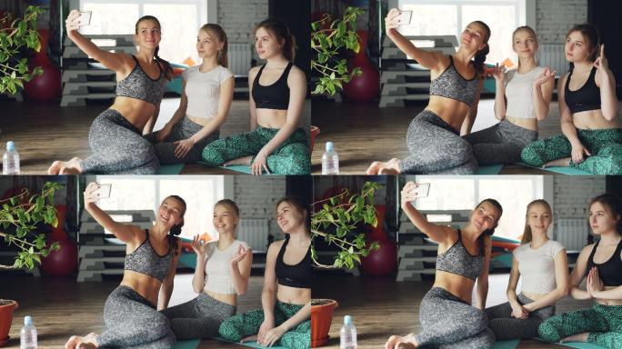 年轻女性在健身房上完瑜伽课后进行自拍。