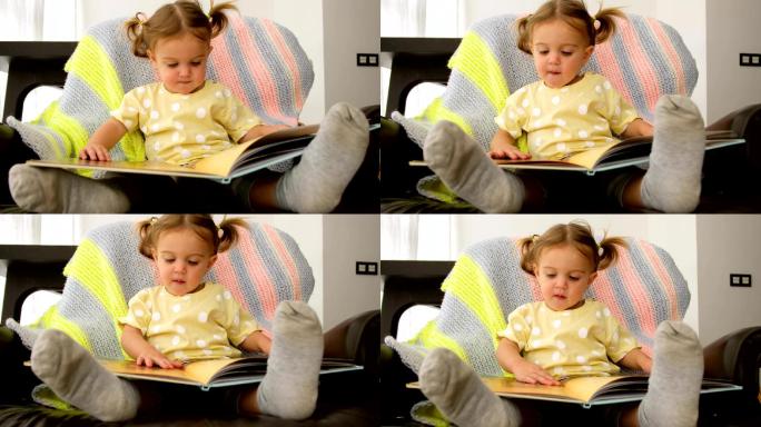 可爱的蹒跚学步的孩子在家看书