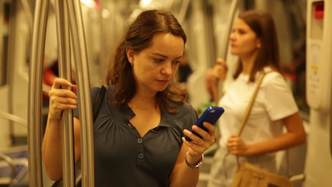 地铁上使用手机的女人