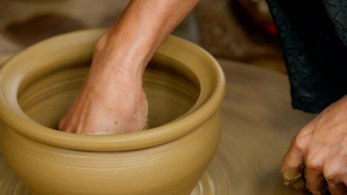 陶工用手在陶工的轮子上塑造陶罐