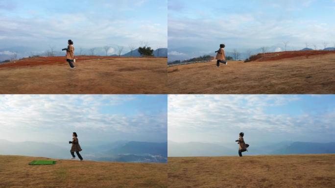 高山上奔跑的女摄影师