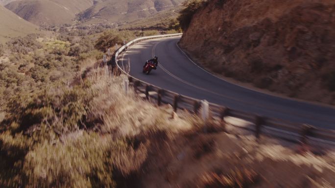 摩托车手在弯曲的道路上骑着摩托车