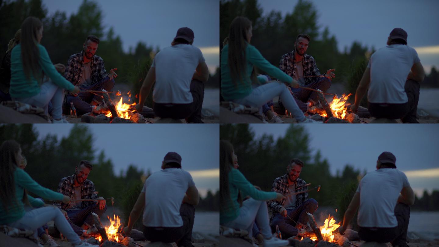 四个年轻的朋友一起坐在篝火旁