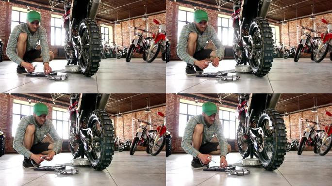 男运动员正在修理他的摩托车