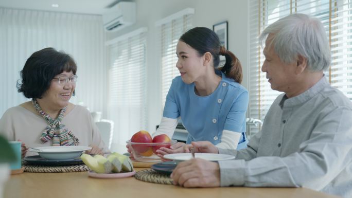 老年人夫妇早上在家里的餐桌上愉快地用餐