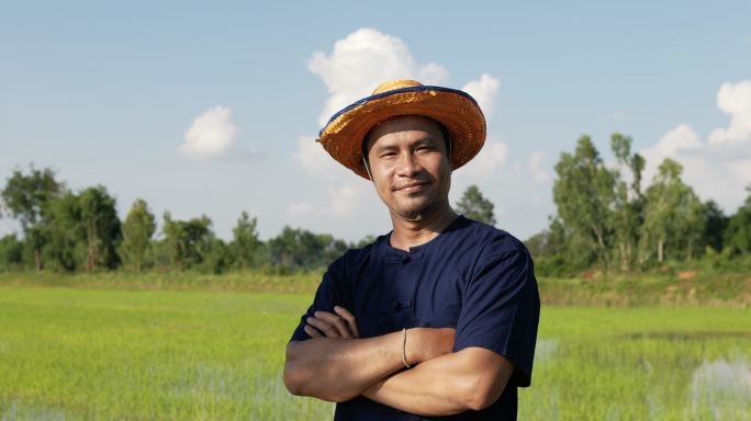 画中年轻的农民站在稻田里