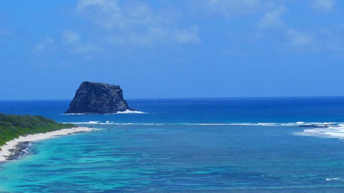 碧海蓝天热带鸟盘旋于岩石岛的航拍素材