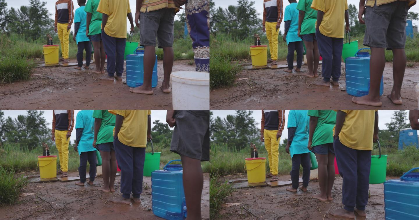 男孩排队从公共供水点收集生活用水。