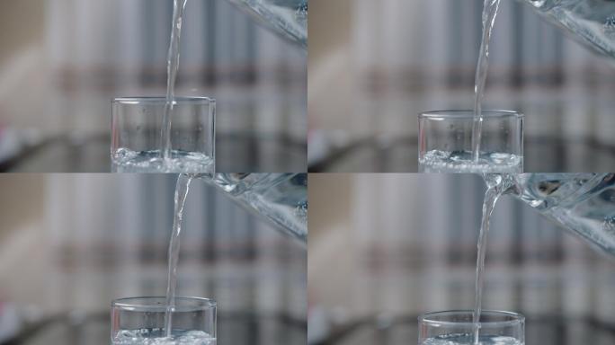 把干净的饮用水从瓶子倒进玻璃杯里