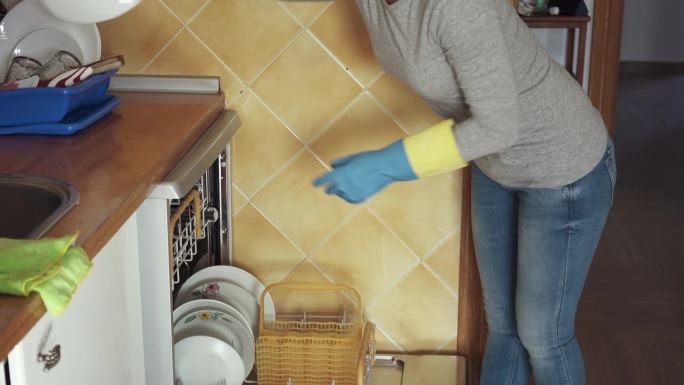 女人在洗碗机里装盘子