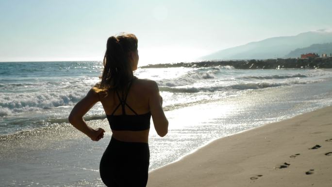 沿着海滩慢跑的运动型女子