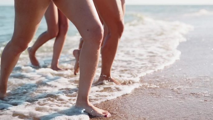 纤细的女性走出沙滩上的海浪。