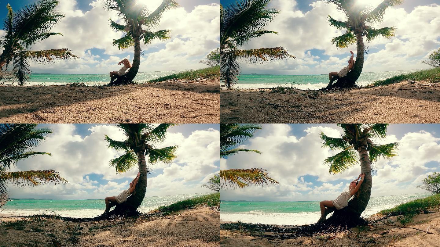 一个女人坐在海边的棕榈树上休息