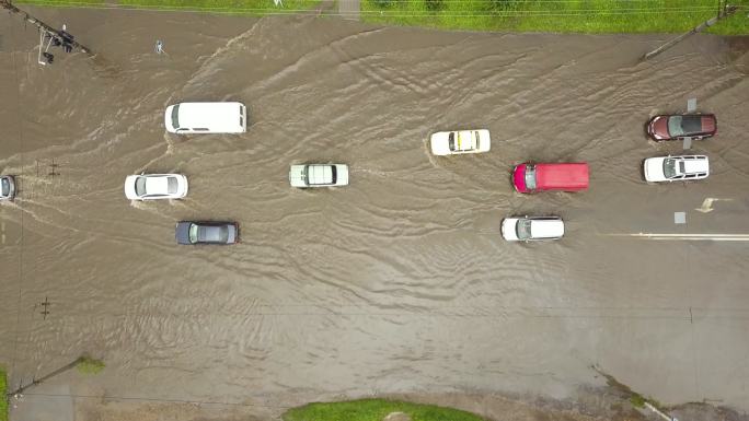 在被雨水淹没的道路上行驶的车辆