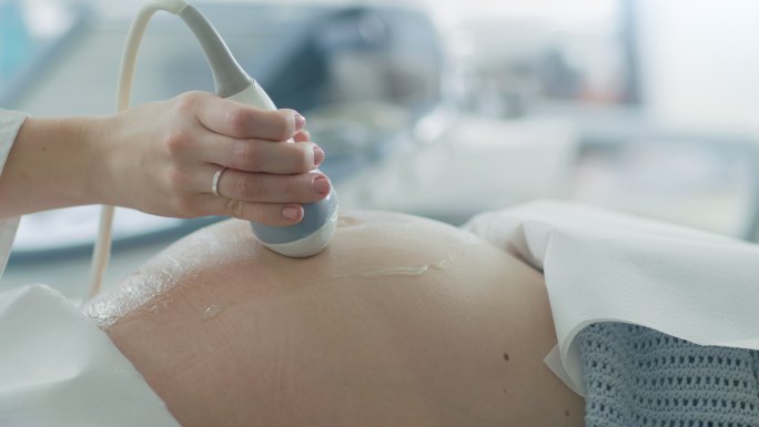 医生对孕妇进行超声波扫描的特写镜头