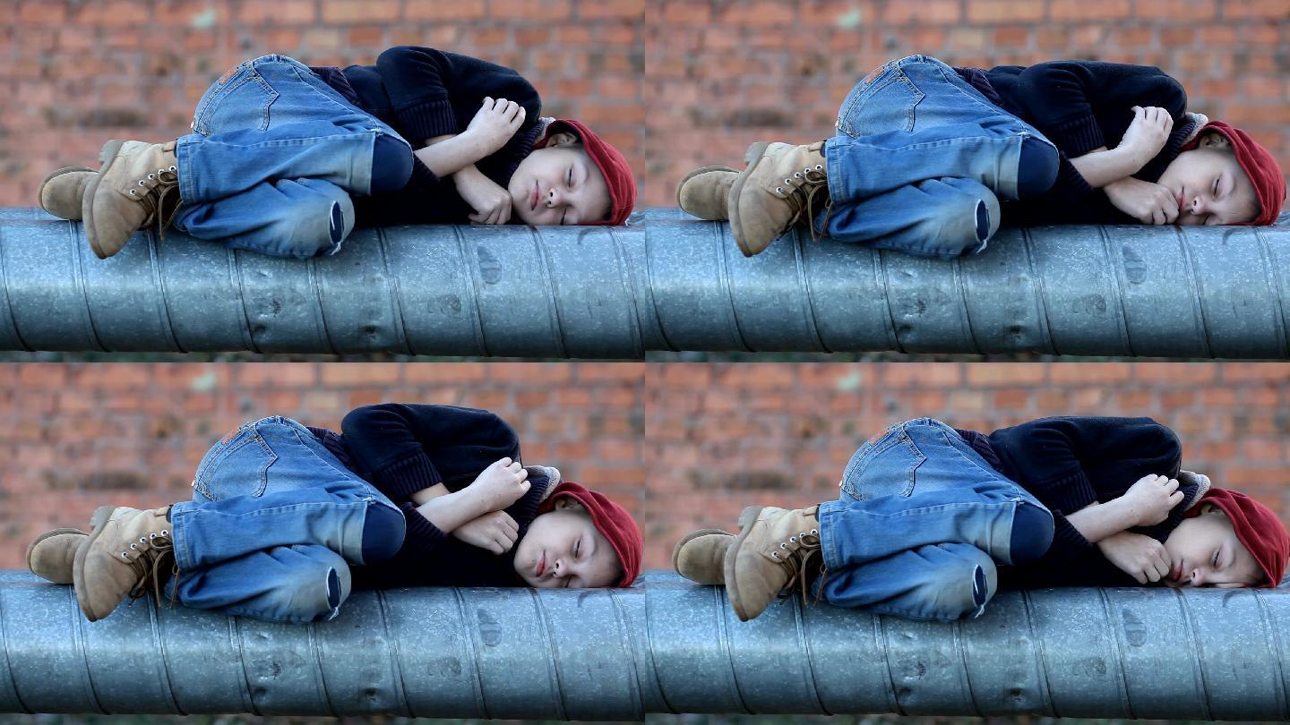 无家可归的小男孩睡在暖气管上