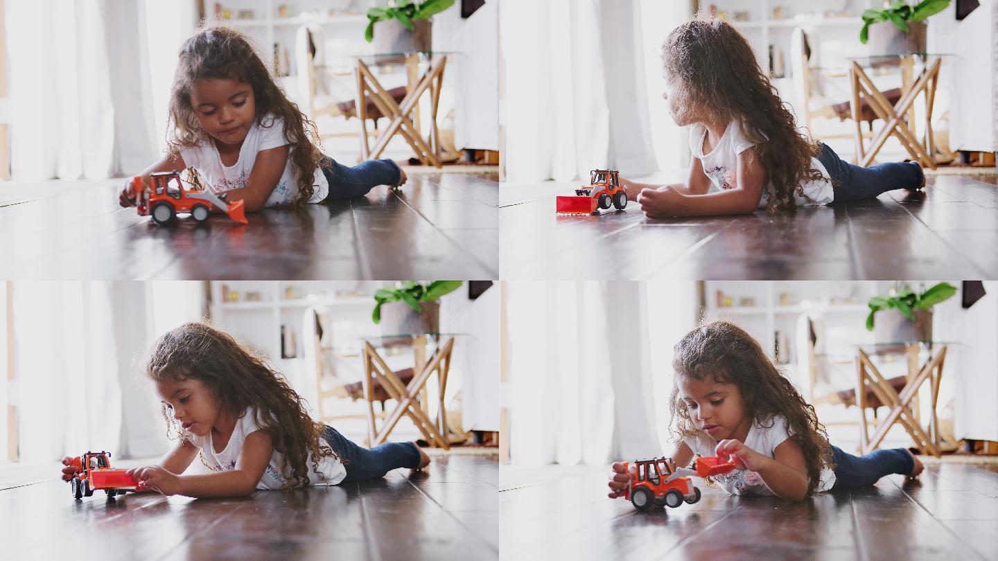 女孩躺在客厅的地板上玩玩具挖掘机
