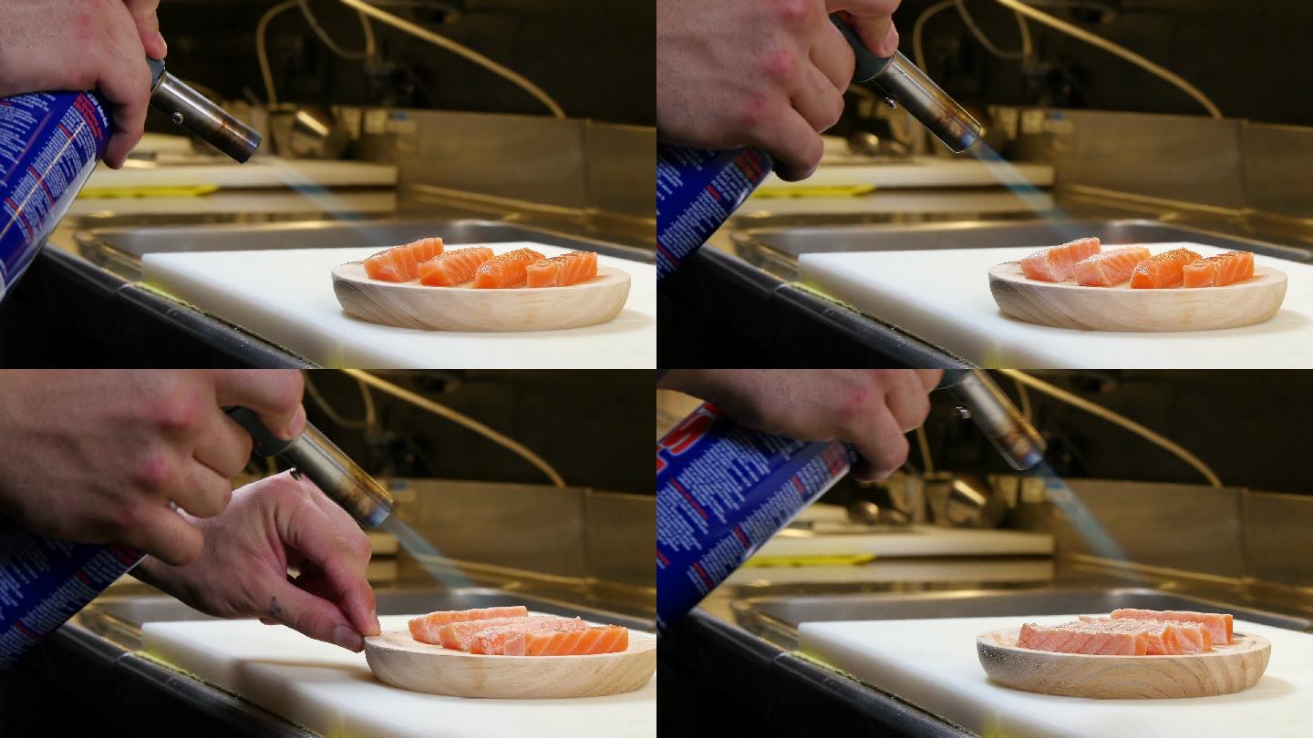 寿司厨师用厨房喷火器烹调三文鱼