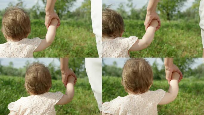 慢镜头：小女婴牵着妈妈的手在公园里散步