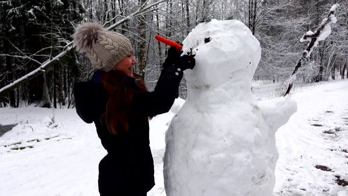 女人用胡萝卜做雪人鼻子