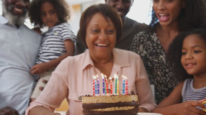多代人家庭在家里用蛋糕庆祝祖母的生日