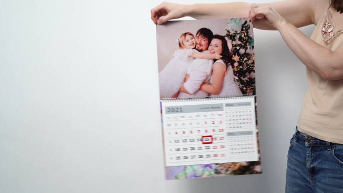 一个女人拿着一个带着全家福照片的日历