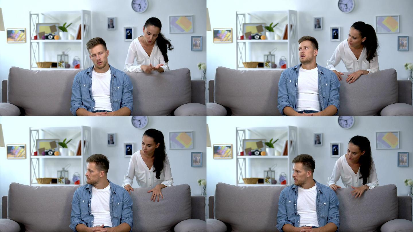 女人批评懒散的坐在沙发上的丈夫
