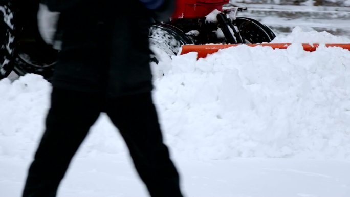 挖掘机清理城市街道上的大量积雪。
