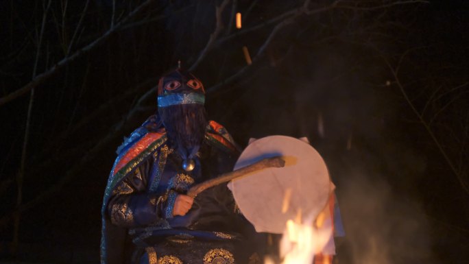 萨满正坐在火旁，进行一个神奇的仪式。