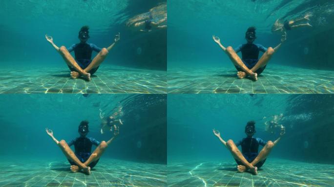 一个年轻人在游泳池底部做瑜伽冥想