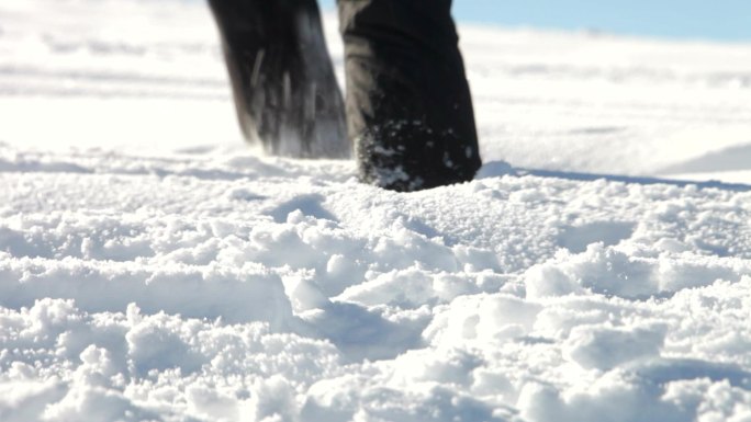 在深雪中艰难跋涉的双脚特写