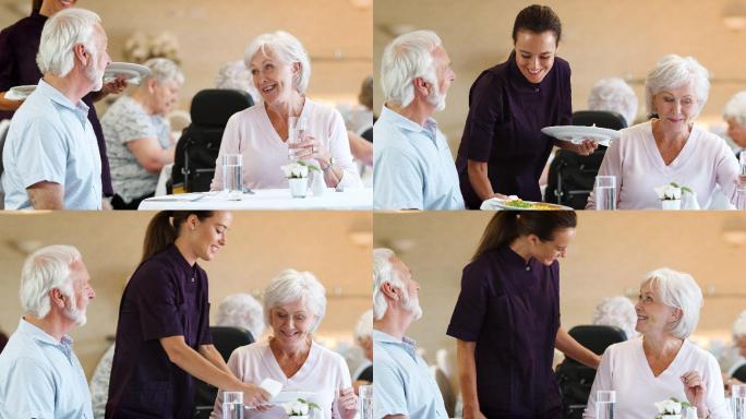 养老院餐厅的看护人为老年夫妇提供膳食