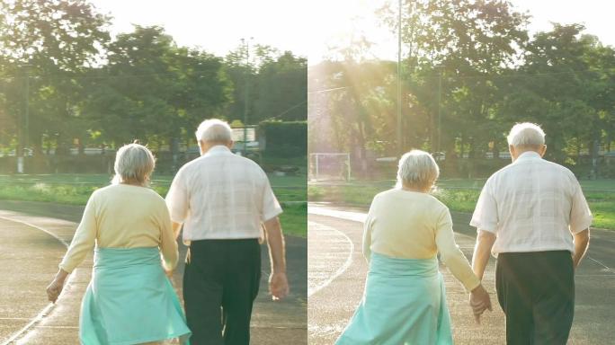 沿着跑道散步的老年夫妇