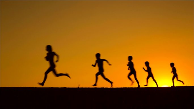 五个奔跑的孩子在夕阳下的剪影