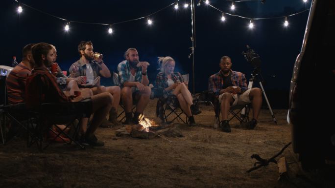 朋友们在营地的篝火旁聊天